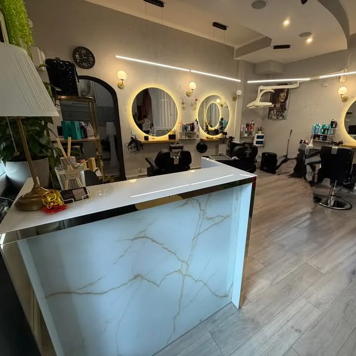 Recepcja salonu z marmurowym frontem, złotymi detalami i roślinami